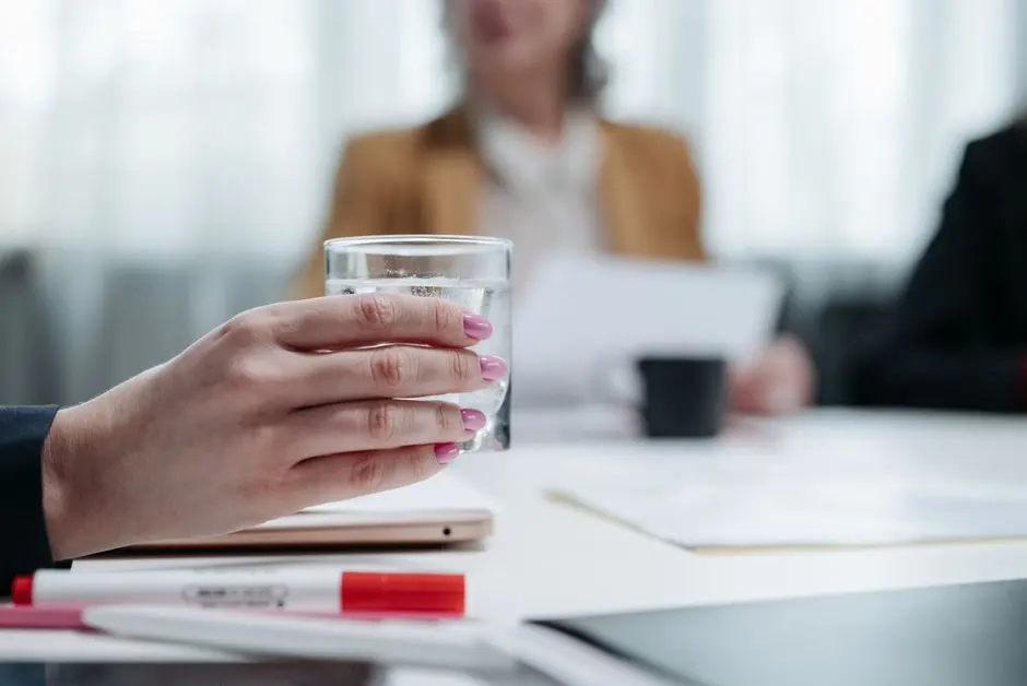 Ilustrasi wanita pekerja kantor sedang minum air putih di meja kerja
